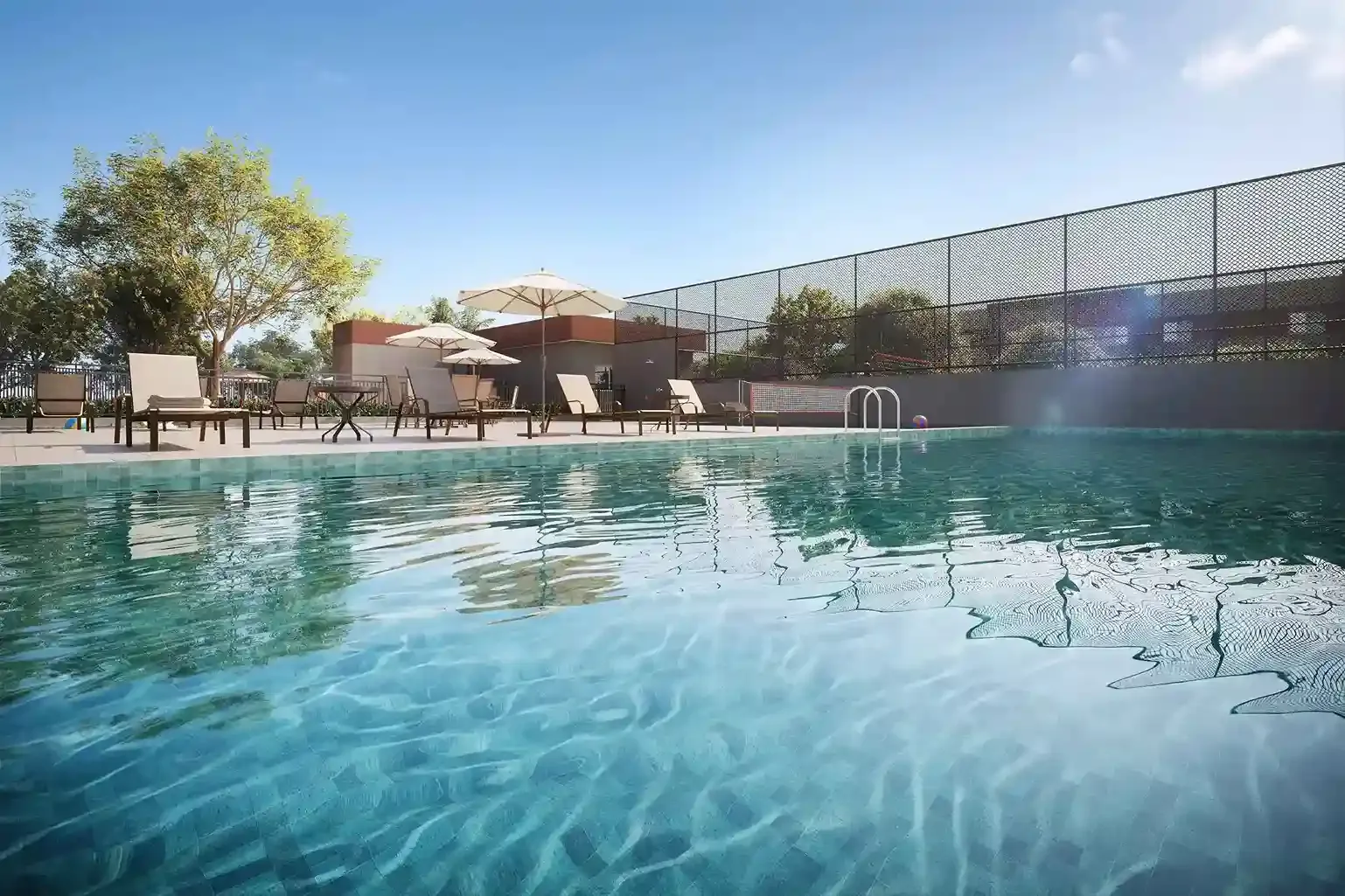 Piscina adulto com espreguiçadeiras e guarda-sóis